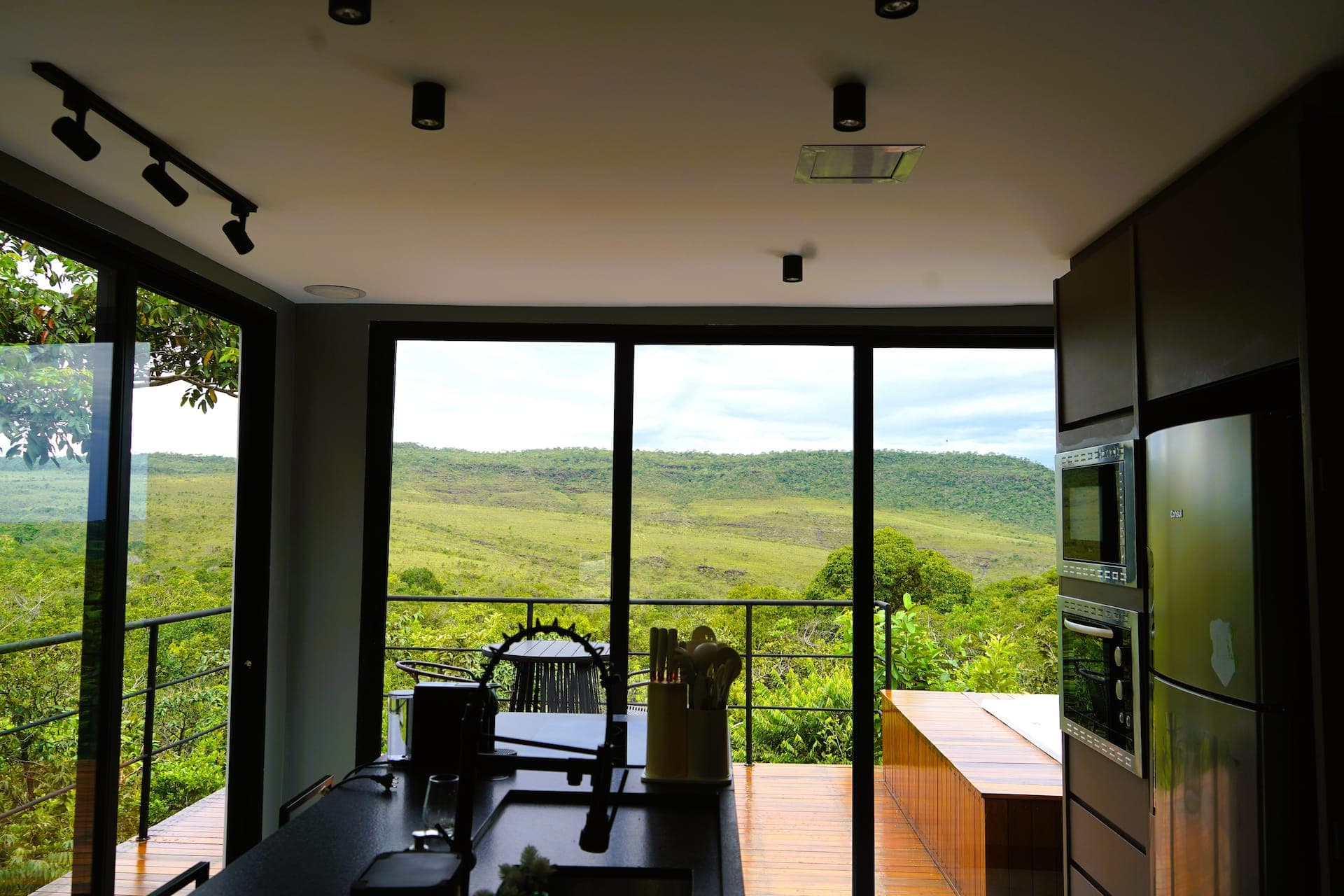 Bancada da cozinha aberta para a varanda com vista panorâmica da serra