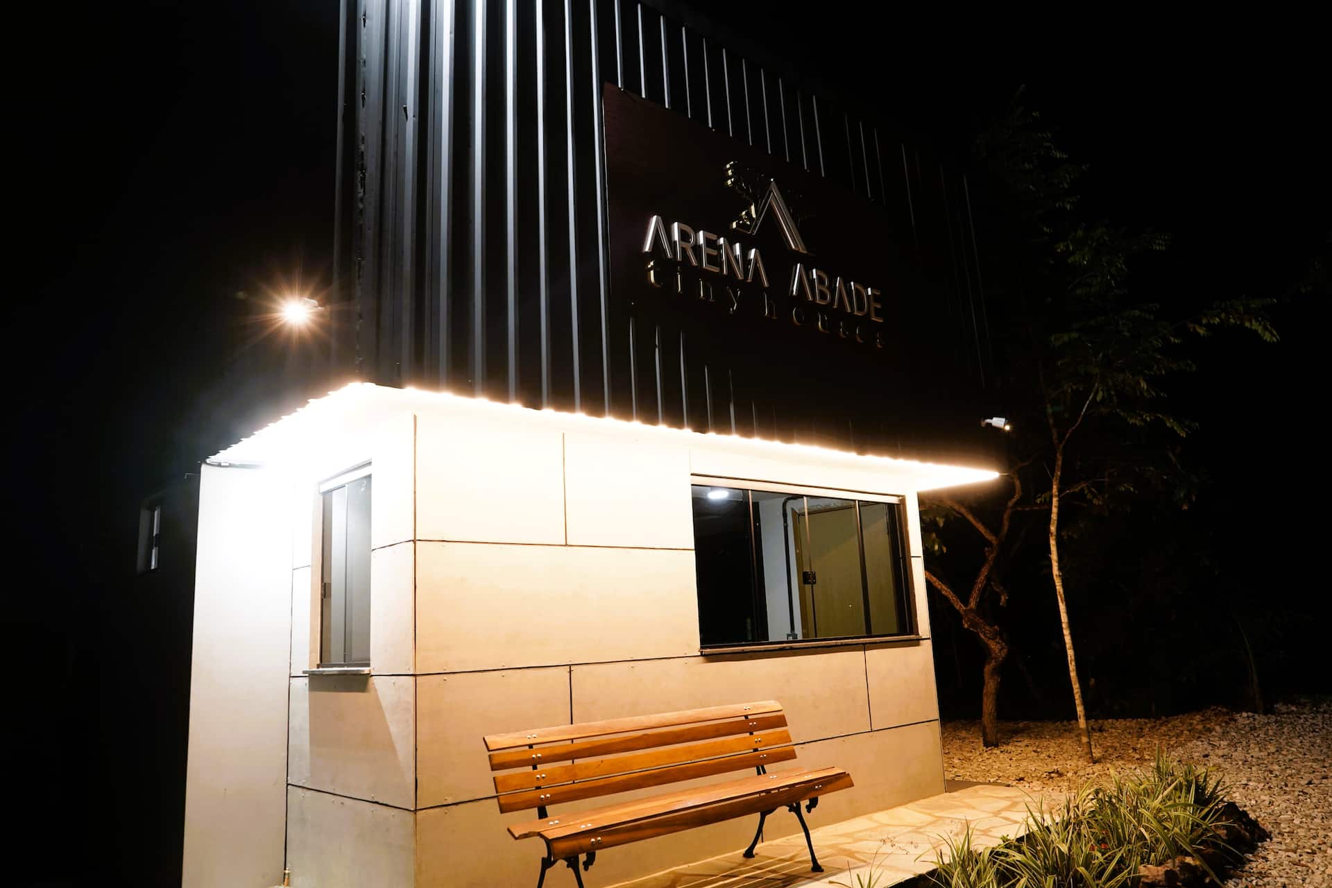 Varanda com portas de vidro abertas para a sala, estrutura em aço preto
