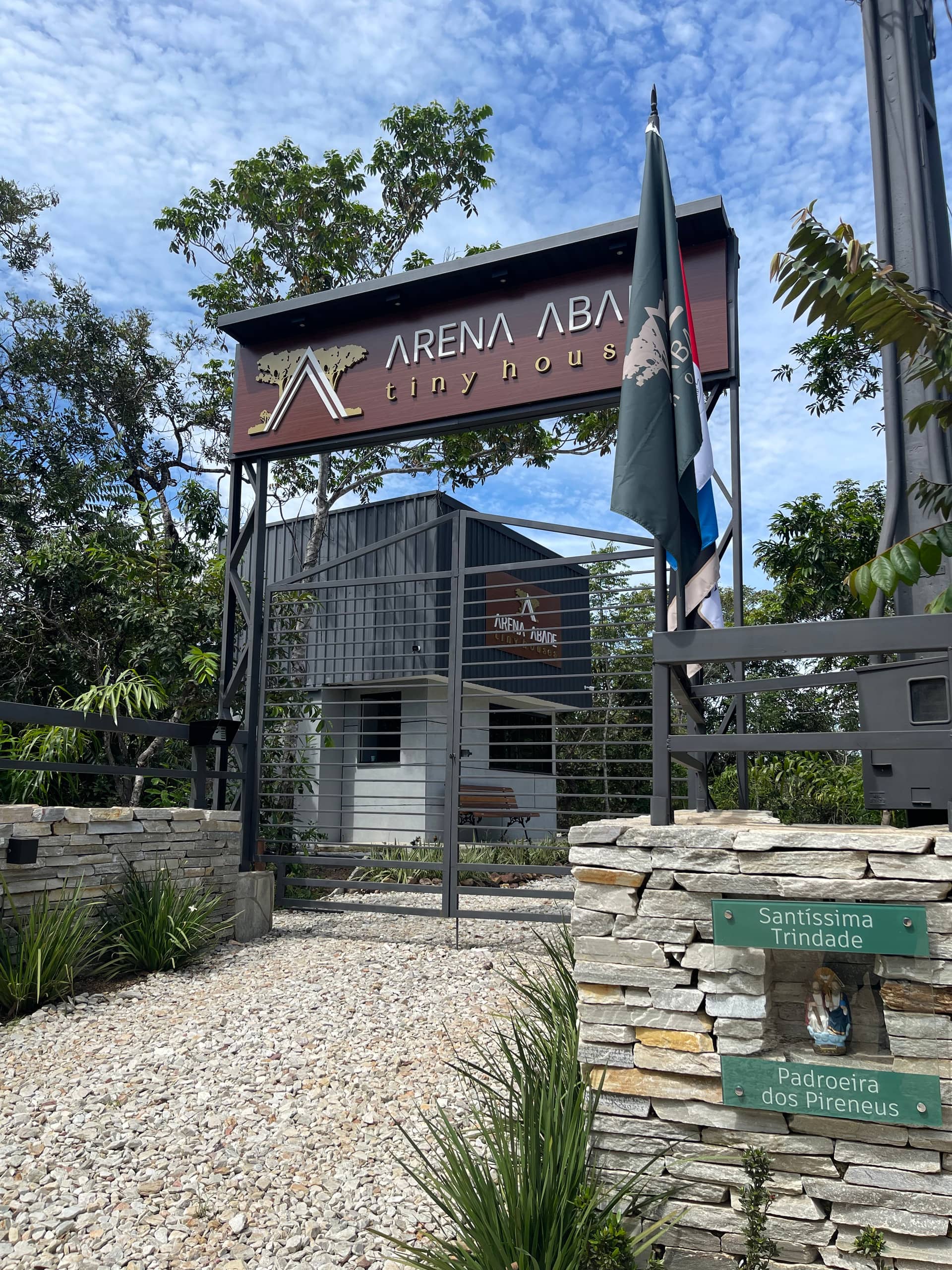 Pórtico de entrada da Arena Abade com bandeiras e letreiro