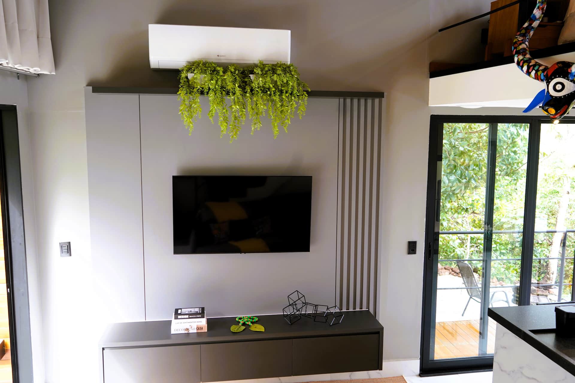 Parede da TV com nicho de plantas suspensas e ripado em grafite